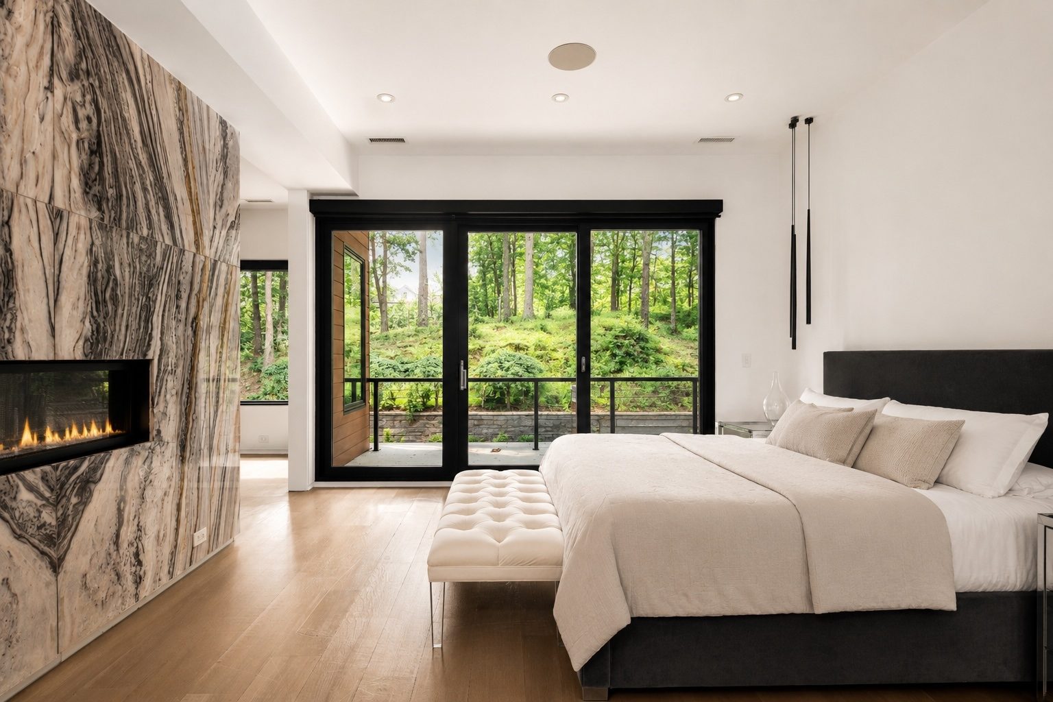 primary bedroom at 15 Seminole Way with a book-matched marble fireplace wall and sliders to a private balcony